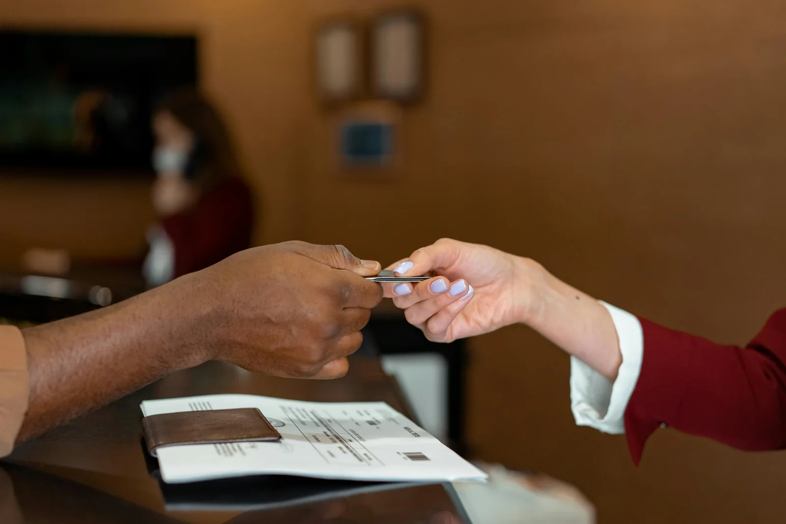A guest receiving a key card during check-in at a hotel reception